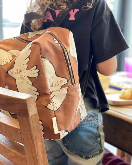 Gepersonaliseerde roze baby of kinder rugzak met speelse vogeltjes print van het merk Studio Loco geborduurd op naam en de tekst peace