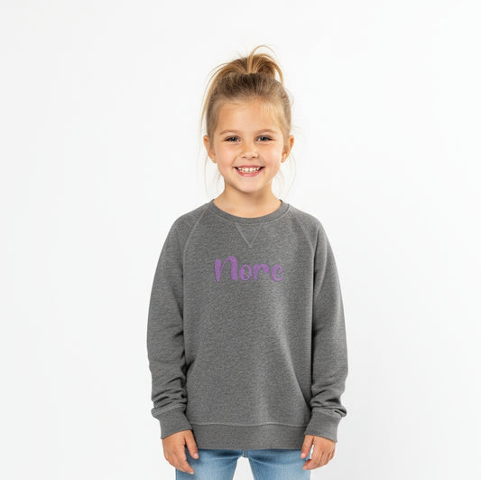 Meisje met gepersonaliseerde sweater met naam borduring