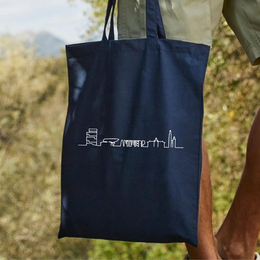 man met tote bag of shopping bag bedrukt met de skyline van de stad Antwerpen