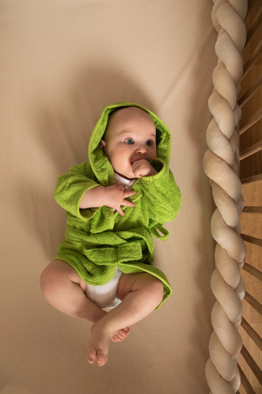 Baby met zachte gepersonaliseerde groene badjas op naam van het merk Tiseco