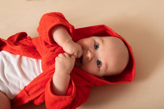 Baby met zachte gepersonaliseerde oranje rode badjas op naam van het merk Tiseco