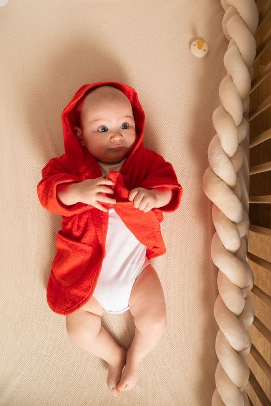 Baby met kwalitatieve gepersonaliseerde rode badjas op naam van het merk Tiseco