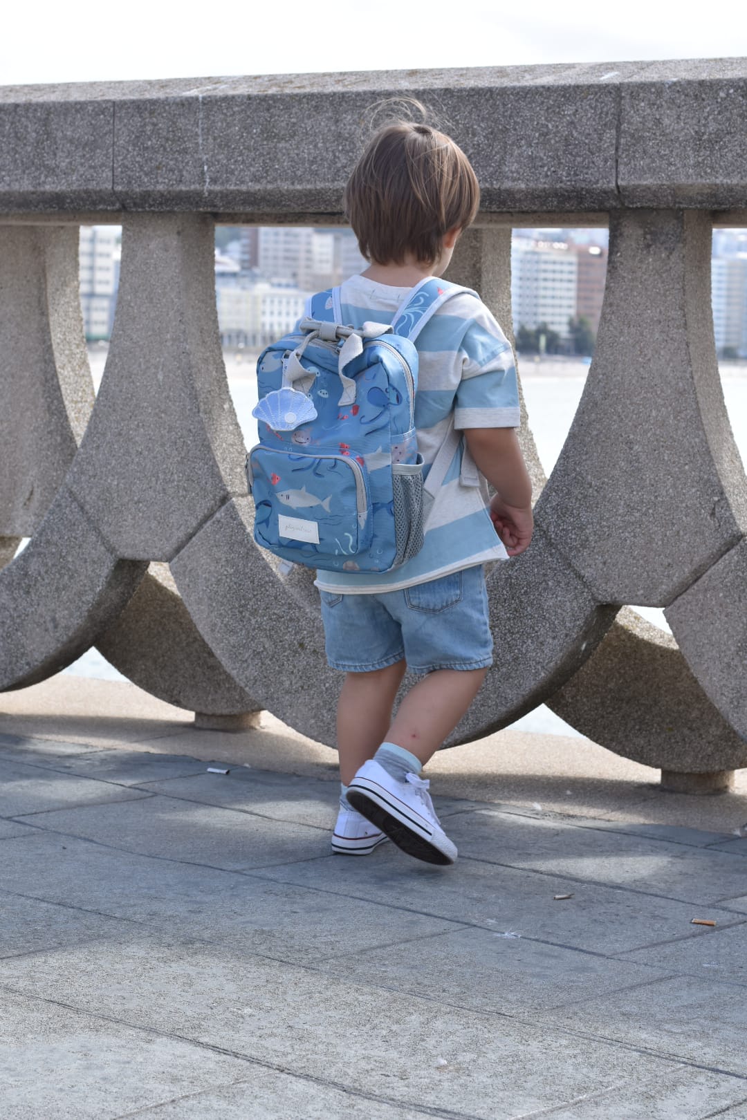 Jongetje met een gepersonaliseerde baby of kinder rugzak met zee thema print van het merk Play and Store geborduurd op naam