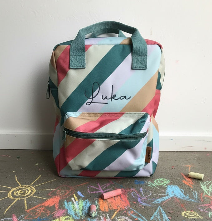 Kleurrijke rugzak met regenboog motief geborduurd met de naam van een kind