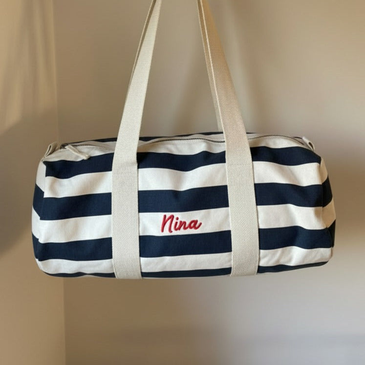 Geborduurde luiertas met strepen motief en de naam van baby