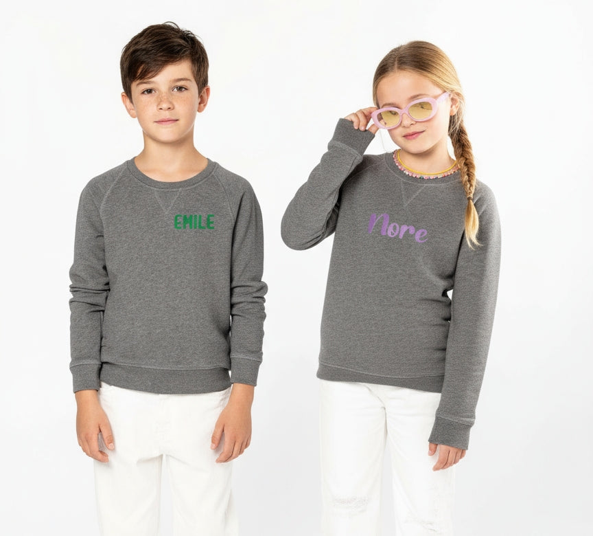 Jongen en meisje met een unieke trui geborduurd op hun naam