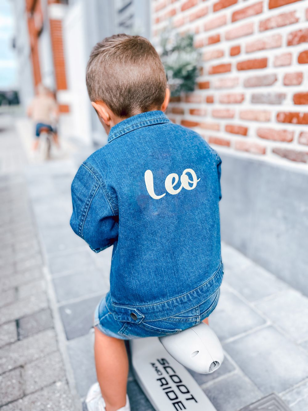 Kleuter met een geborduurde jeansvest met zijn naam in mooi lettertype